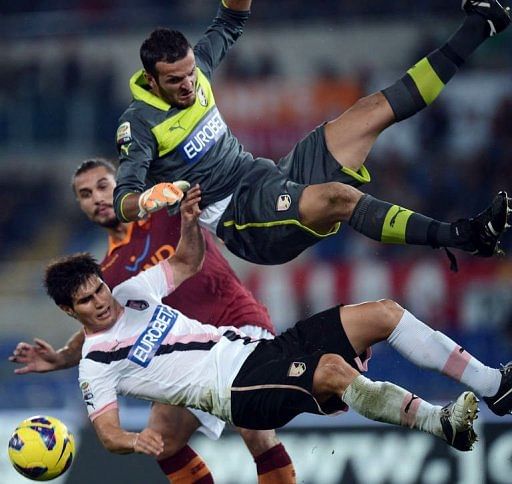 Palermo&#039;s Samir Ujkani (R) and Ezequiel Munoz (L) fight for the ball with AS Roma&#039;s Pablo Daniel Osvaldo (C)