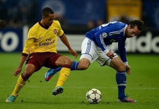 Schalke&#039;s Christian Fuchs (R) and Arsenal&#039;s Theo Walcott fight for the ball