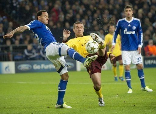 Arsenal&#039;s Lucas Podolski (C) and Schalke&#039;s Jermaine Jones (L) fight for the ball