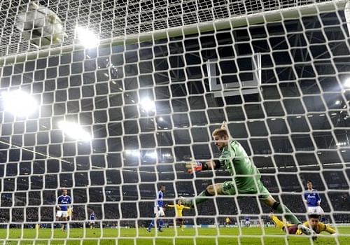 Arsenal's Olivier Giroud (R) heads past Schalke's goalkeeper Lars Unnerstall to score