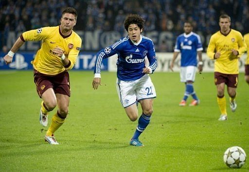 Schalke&#039;s Japanese defender Atsuto Uchida (R) vies for the ball with Arsenal&#039;s French striker Olivier Giroud