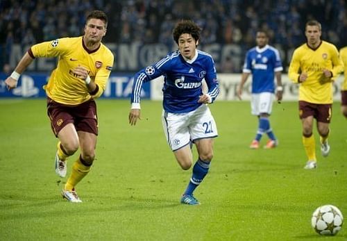 Schalke's Japanese defender Atsuto Uchida (R) vies for the ball with Arsenal's French striker Olivier Giroud