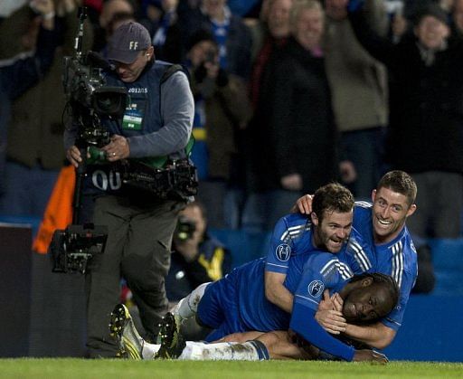 Chelsea&#039;s Victor Moses (bottom) is jumped on by teammates Gary Cahill (R) and Juan Mata (C) after scoring winning goal