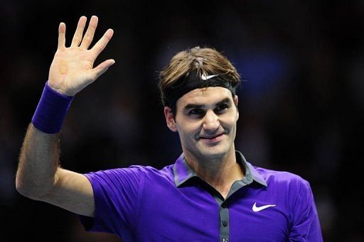 Switzerland&#039;s Roger Federer waves as he celebrates beating Spain&#039;s David Ferrer in their group B singles match in London