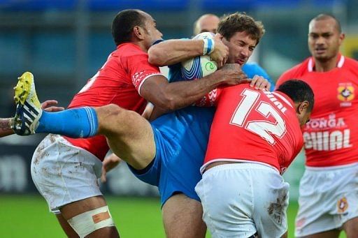 Italy centre Tommaso Benvenuti (C) is tackled by Tonga fullback Lilo Vungakoto (L) and centre Sione Piukala