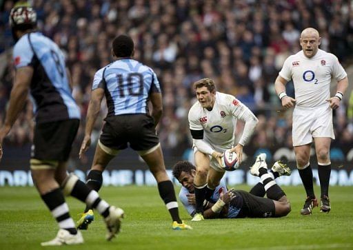 England full-back Alex Goode (C) tries to get a pass away as he gets tackled by Fiji&#039;s Sireli Naqelevuki