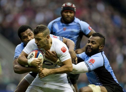 England&#039;s scrum half Danny Care (2nd L) gets tackled by Fiji&#039;s Nikola Matawalu (L) and Metuisela Talebula