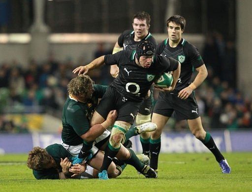 Ireland&#039;s hooker Richardt Strauss (2nd R) evades a tackle from South Africa&#039;s prop Jannie du Plessis (2nd L)