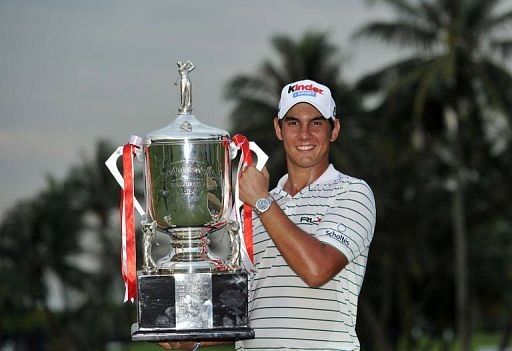 Matteo Manassero poses with the winner&#039;s trophy on day four of the Singapore Open