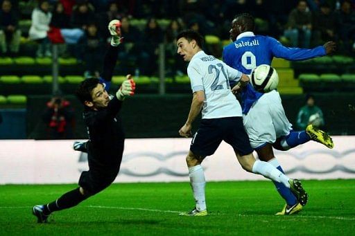 France&#039;s goalkeeper Hugo Lloris (L) and Anthony Reveillere fight for the ball with Italy&#039;s Mario Balotelli