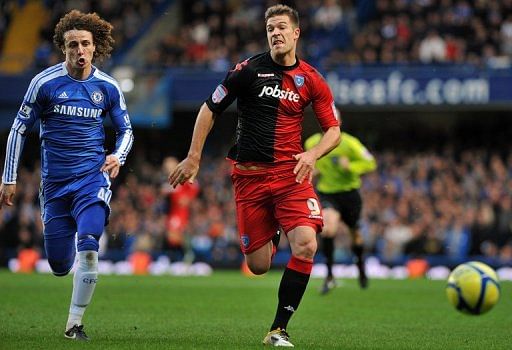 Portsmouth&#039;s Hungarian striker Marko Futacs (R) chases the ball in January 2012