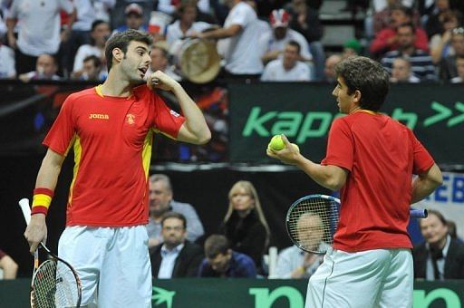 Spanish tennis player Marcel Granollers (L) talks with his teammate Marc Lopez