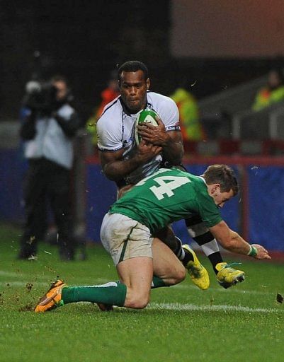 Ireland wing Craig Gilroy tackles Fiji wing Simeli Koniferedi (L)