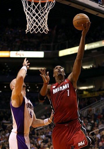Chris Bosh (R) scored 24 points to help lift Miami to a 97-88 victory over the Phoenix Suns
