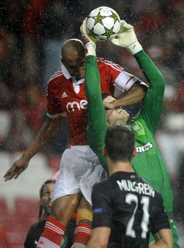 Celtic&#039;s English goalkeeper Fraser Forster catches the ball past Benfica&#039;s Brazilian defender 