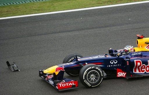 Sebastian Vettel passes by debris from a car at the S of Senna turn