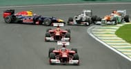 Fernando Alonso leads a pack ahead of Felipe Massa, as Mark Webber (L) loses control of his Red Bull