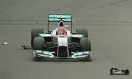 Michael Schumacher passes over debris from Mark Webber's car