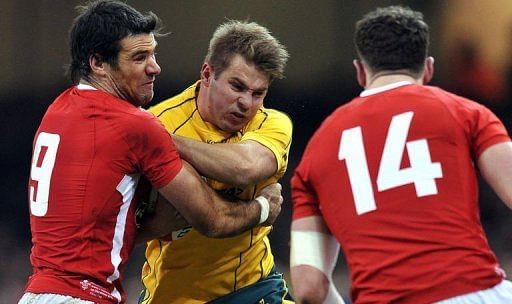 Australia&#039;s wing Drew Mitchell (centre) is tackled by Wales&#039;s scrum half Mike Phillips (left) and wing Alex Cuthbert