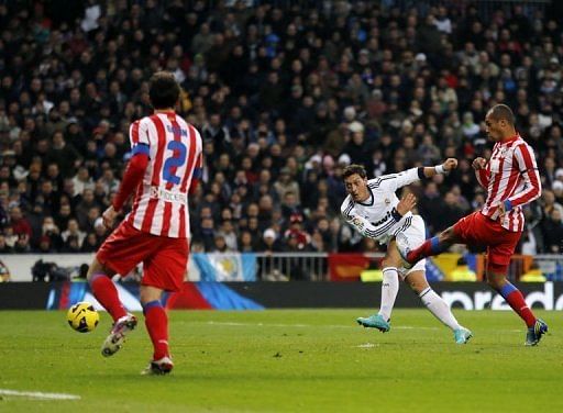 Real Madrid midfielder Mesut Ozil scores the second goal during their match against Atletico Madrid