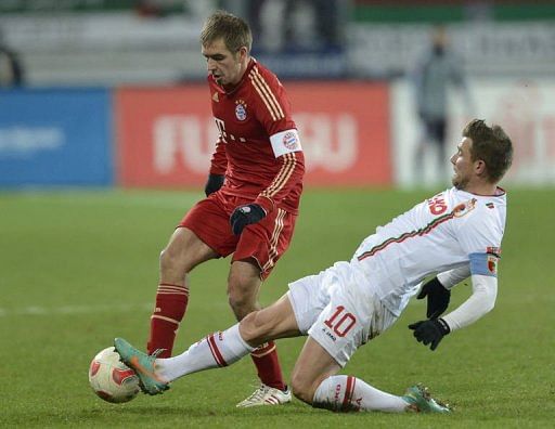 Bayern Munich&#039;s defender Philipp Lahm (L) and Augsburg&#039;s midfielder Daniel Baier challenge for the ball