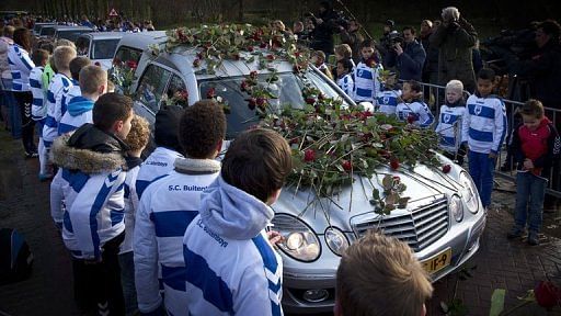 Members of SC Buitenboys lay roses on a hearse carrying the body of linesman Richard Nieuwenhuizen on December 10, 2012