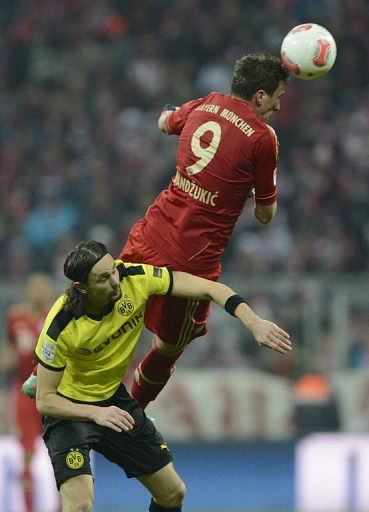 Bayern striker Mario Mandzukic outjumps Dortmund&#039;s Neven Subotic during the German Bundesliga match on December 1, 2012