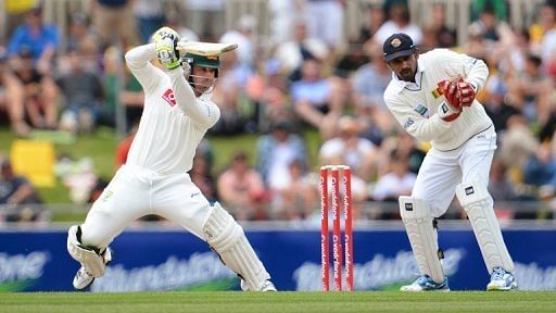 Australian batsman Phil Hughes (L) cuts a ball during the first day of the first Test in Hobart on December 14, 2012