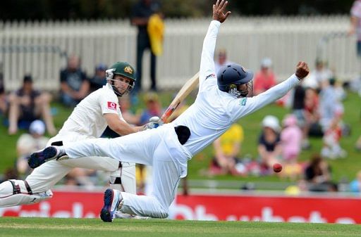 Sri Lanka&#039;s Dimuth Karunaratne (R) attempts a catch by Australia&#039;s Matthew Wade, in Hobart, on December 15, 2012