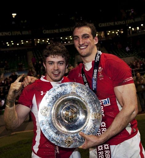 Wales&#039; Sam Warburton (R) and Leigh Halfpenny, pictured with the Triple Crown trophy, in London, on February 25, 2012