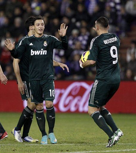 Real Madrid&#039;s Mesut Ozil (L) celebrates scoring a goal against Real Valladolid, on December 8, 2012