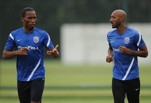 Shanghai Shenhua players Didier Drogba (L) and Nicolas Anelka warm up during a training session on July 16, 2012