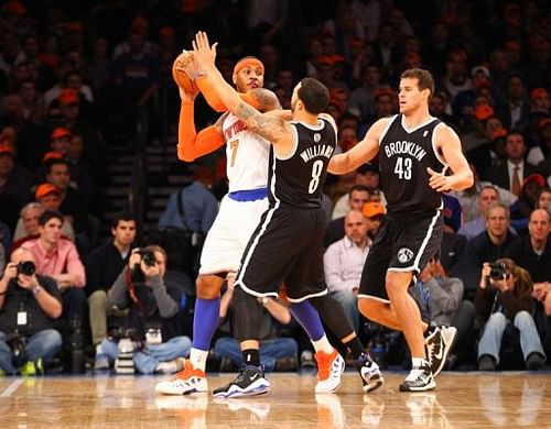 Carmelo Anthony (L) is blocked by the Nets' Deron Williams (C) and Kris Humphries during their game on December 19, 2012