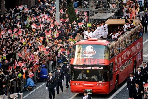 The Tokyo Yomiuri Giants wave to thousands of fans during a parade to celebrate their victory on November 25, 2012