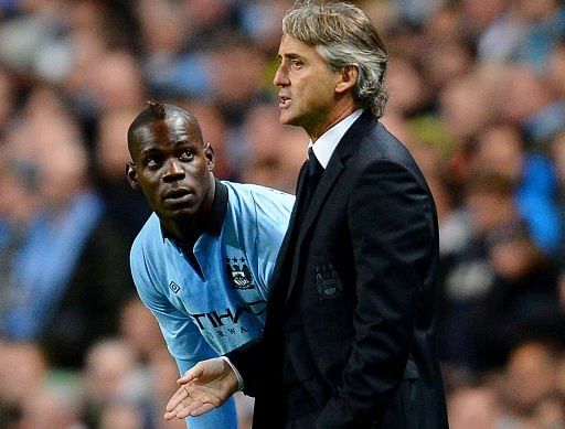 Manchester City manager Roberto Mancini (R) speaks to striker Mario Balotelli during a match on October 3, 2012