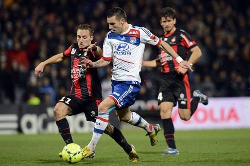 Lyon&#039;s forward Anthony Reveillere (C) fights for the ball with Nice&#039;s forward Eric Bautheac in Lyon on December 22, 2012