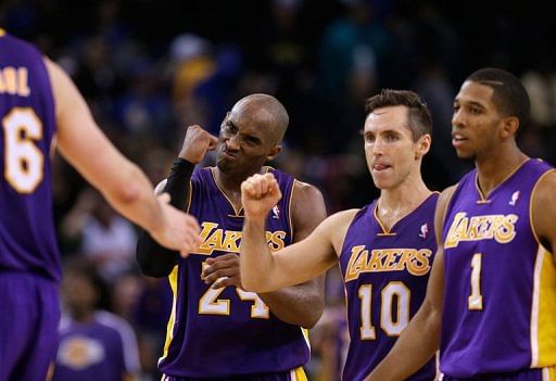 Kobe Bryant (C) of the Lakers celebrates with teammates Steve Nash (2nd R) and Darius Morris (R) on December 22, 2012