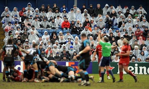 Fans watch in the rain as the Sale Sharks play Toulouse in Stockport, England on January 24, 2010