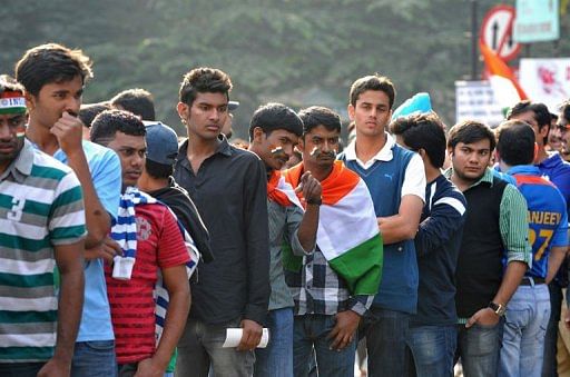 Indian cricket fans wait in line outside The M. Chinnaswamy Stadium in Bangalore on December 25, 2012