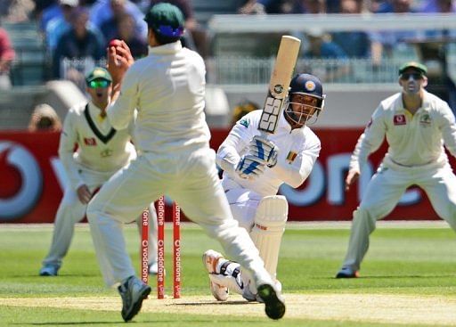 Kumar Sangakkara drives a ball at Australian fielder Ed Cowan (2nd L) in the second Test on December 26, 2012