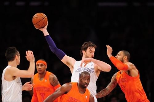 Pau Gasol (C) of the Los Angeles Lakers grabs the ball against the New York Knicks on December 25, 2012