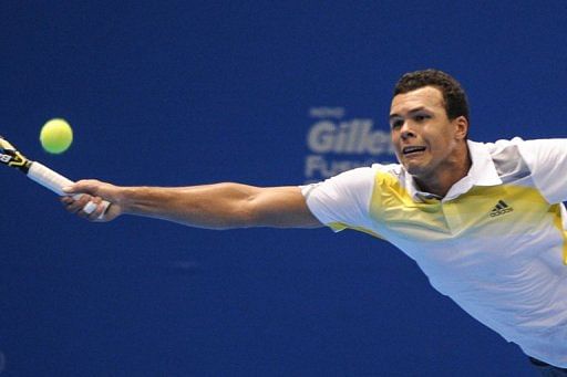 Jo-Wilfried Tsonga returns a shot against Roger Federer during an exhibition match in Sao Paulo on December 8, 2012