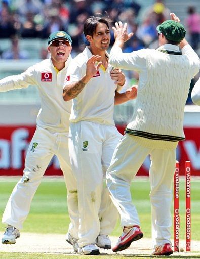 Australia&#039;s Mitchell Johnson (C) is congratulated by David Warner (L) and Michael Hussey, on December 28, 2012