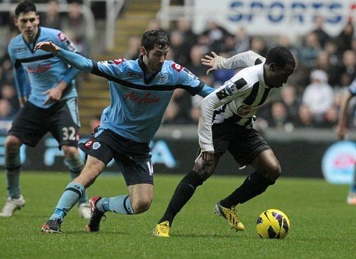Newcastle midfielder Vurnon Anita (R) turns away from QPR midfielder Esteban Granero on December 22, 2012