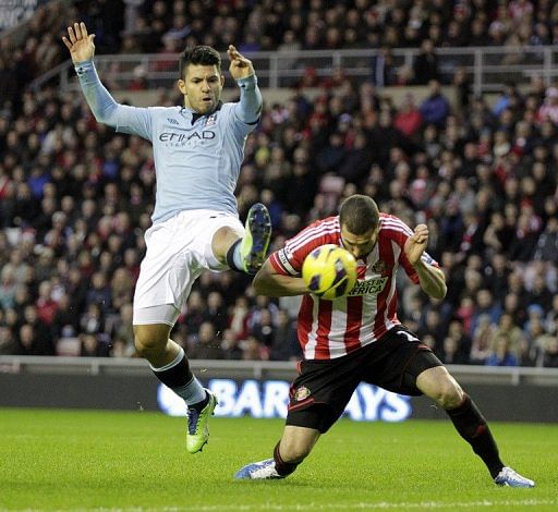 Sunderland&#039;s Carlos Cuellar (R) fights for the ball with Manchester City&#039;s Sergio Aguero, on December 26, 2012