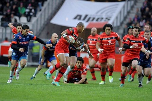 Toulouse&#039;s centre Gael Fickou (C) passes the ball during their Top 14 match against Grenoble, on December 22, 2012