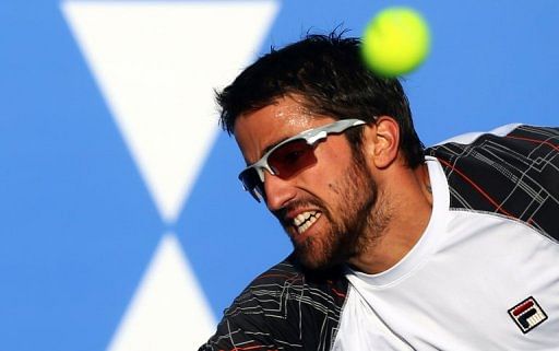 Janko Tipsarevic returns the ball to Spain&#039;s David Ferrer in Abu Dhabi on December 29, 2012