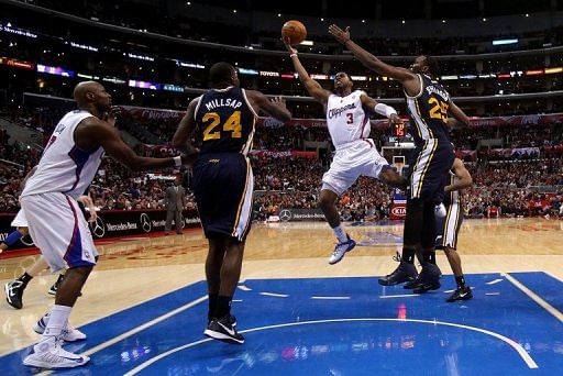 Chris Paul (C) of the L.A. Clippers shoots between Paul Milsap and Al Jefferson of the Utah Jazz, on December 30, 2012
