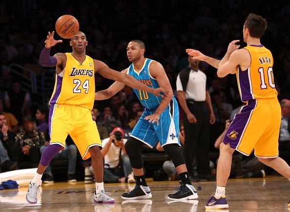 LOS ANGELES, CA - JANUARY 29:   Kobe Bryant #24 of the Los Angeles Lakerscatches a pass from Steve Nash #10 in front of Eric Gordon #10 of the New Orleans Hornets 