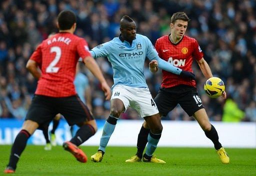 Mario Balotelli (C) tussles with Manchester United&#039;s Michael Carrick (R) at the Etihad Stadium on December 9, 2012